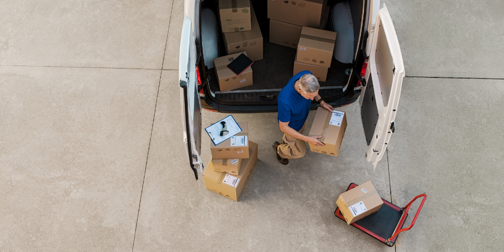 Courier driver loading parcels into the back of a delivery van